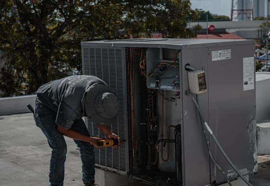 HVAC technician checking refrigerant levels on an outdoor AC unit