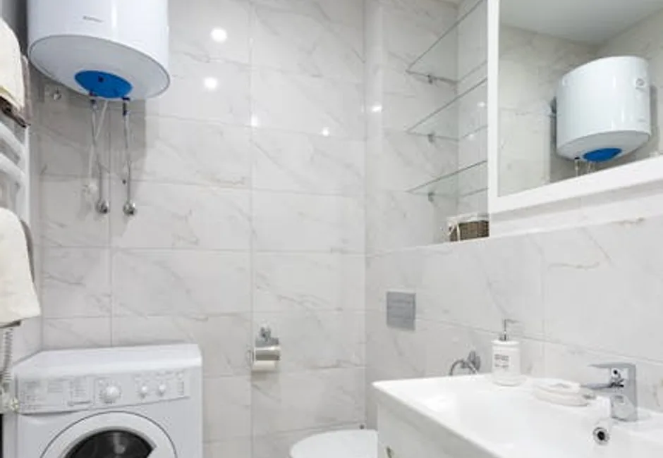 Tank and tankless water heaters compared in a home utility room